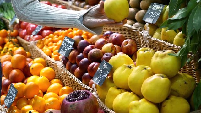 woman in the fruit market with apple in hand. fruits and vegetables. a lot of fruits. market. store. background. citruses. healthy food. natural.. food. health.VEGETARIAN. diet