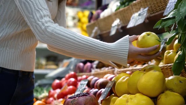 woman in the fruit market with apple in hand. fruits and vegetables. a lot of fruits. market. store. background. citruses. healthy food. natural.. food. health.VEGETARIAN. diet