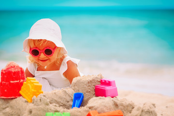 cute little girl play with sand on beach