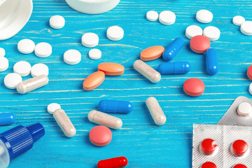 Many different pills on dark blue wooden background