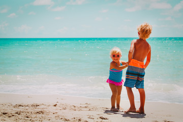 Naklejka premium happy boy and girl play on beach vacation