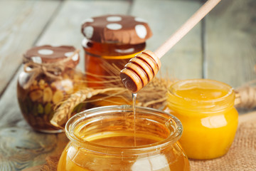 Honey background. Sweet honey in glass jar on wooden background.