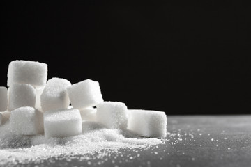 White sugar cubes over black background close up
