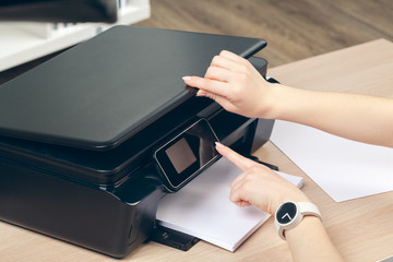 Woman making photocopy using copier in office