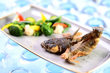 fried fish with vegetables. Roast goby