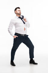 overweight man in tight formal wear with hand in pocket posing on white