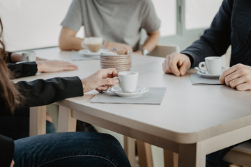 Business meeting in a café: coffee small cup, saucer, coffee spoon and napkin
