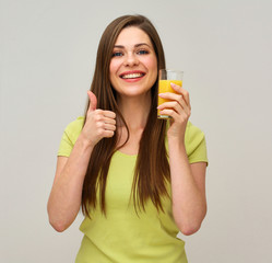 smiling woman holding glass with orange juice doing thumb up.