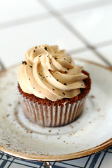 Chocolate homemade cupcakes with earl gray tea buttercream frosting on white plate. Dessert bakery style food photo 