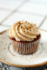 Chocolate homemade cupcakes with earl gray tea buttercream frosting on white plate. Dessert bakery style food photo 