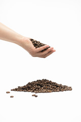 Coffee grains are poured from the palm to the pile