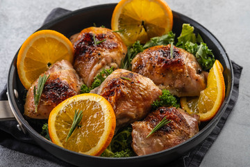 Chicken thighs with orange is a pan.
