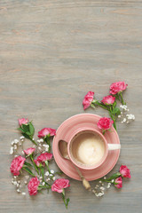 Fototapeta na wymiar Cup of creamy coffee with flowers decor