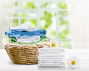 Laundry Basket with colorful towels on background