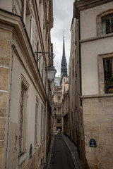 Fototapeta na wymiar Spire of Notre Dame de Paris Cathedral. Old narrow street in Paris, France, Europe