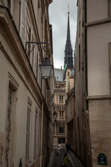 Fototapeta na wymiar Spire of Notre Dame de Paris Cathedral. Old narrow street in Paris, France, Europe