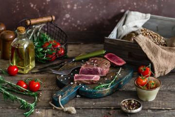 cut meat with blood vegetables oil bread around wooden table