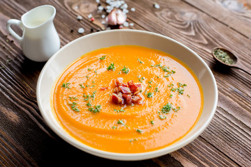 Homemade dieting cream soup with pumpkin, bacon, spices, salt and ginger.