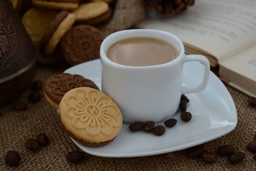 A cup of coffee. While reading a book, have a cup of coffee with cookies. Stop for a minute, coffee is a pleasure.