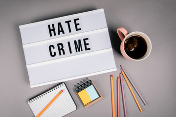 Hate Crime. Text in light box. Pink coffee mug on gray background