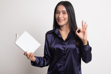 Young Asian woman show OK with a book.