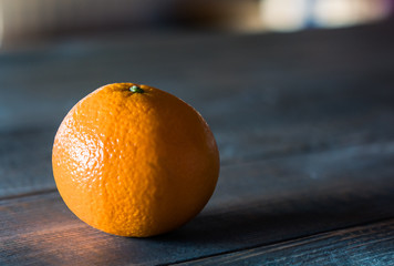 Single orange isolated on rustic wooden table