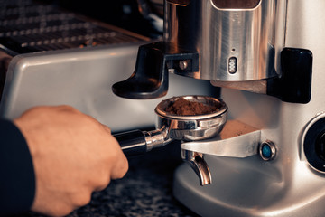 Waiter who is making coffee: coffee machine and coffee powder