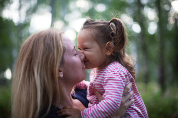 Beautiful woman and her little daughter having fun in the meadow, single mother concept, copy space