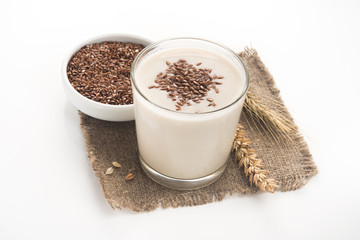 Oat milk in a glass dusted with flax grains