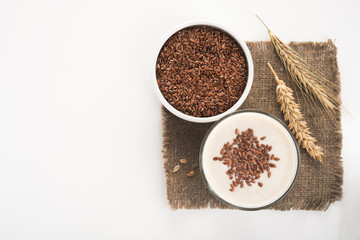 Oat milk in a glass dusted with flax grains