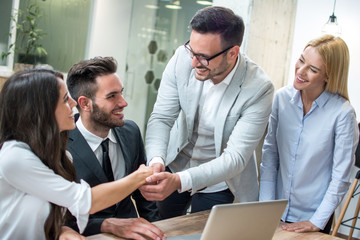 Business people shaking hands after successful meeting in modern office