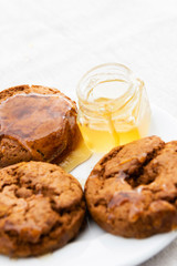 Closeup of honey jar and biscuits.