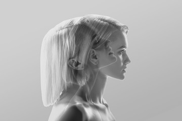 multiple exposure of beautiful blonde woman profile on grey