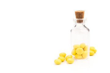 Yellow round vitamin pills in glass bottle