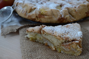 Apple pie with cinnamon. Wooden background.