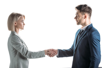 young business partners shaking hands and looking at each other isolated on white