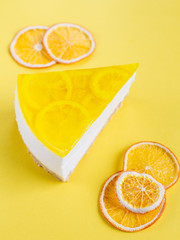 piece of lemon cheesecake on yellow background