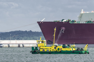 LNG TANKER - Ship moored to the gas terminal and dredger at work