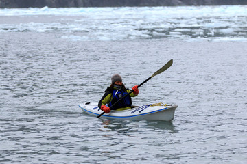 Fototapeta na wymiar 氷河の海でシーカヤックする観光客