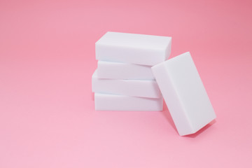 Melamine household sponge stack with four sponges for cleaning on pink background. Cleaning concept