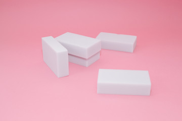 Melamine household sponge stack with four sponges for cleaning on pink background. Cleaning concept