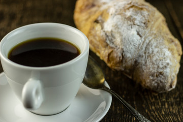 Cup of coffee and sweet buns on a rough wooden background