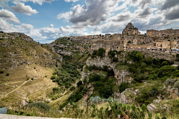 Summer day scenery street view of the amazing ancient town of the Sassi with white puffy clouds...