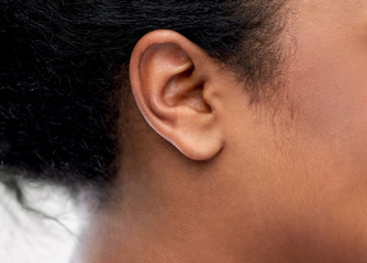 health, people and hearing concept - close up of young african american woman ear