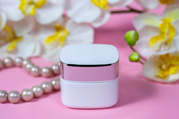 jar of cream pink background with flowers