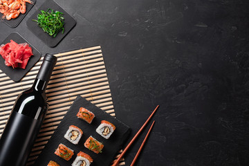 Set of sushi and maki with a bottle of wine on stone table. Top view