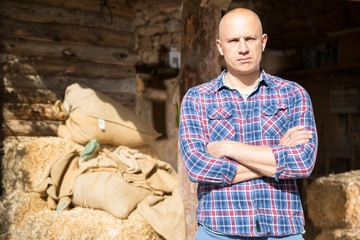 Confident farmer standing near barn
