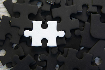 White jigsaw puzzle piece on black jigsaw puzzle