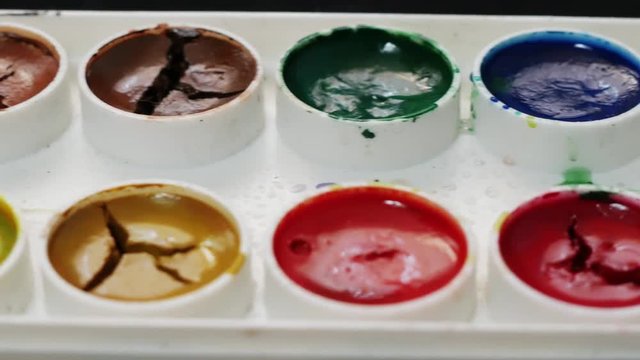 Set of watercolor paints on the black background