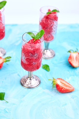 Summer refreshing strawberry sorbet, slush granita drink in serving glasses.